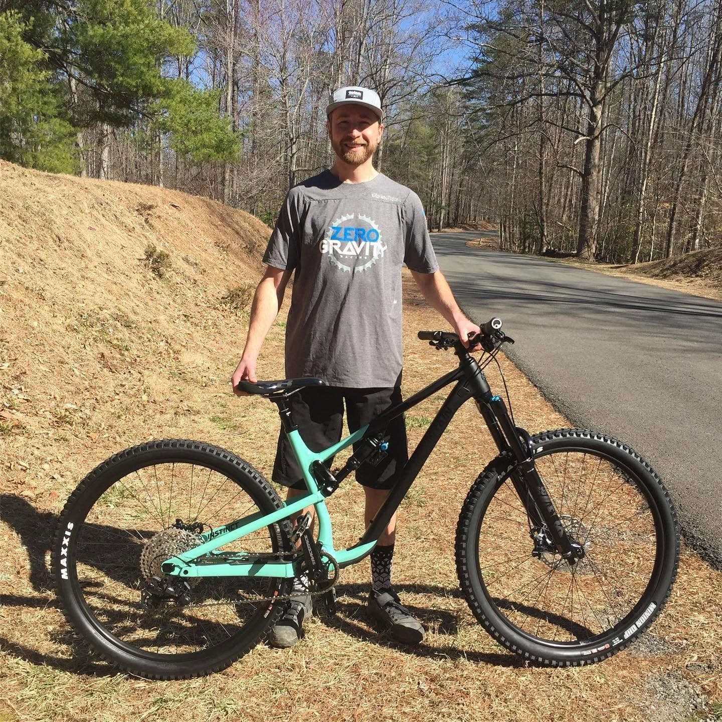 Rider standing next to his new black and teal Rocky Mountain Instinct