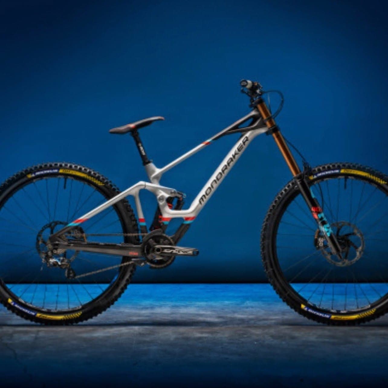 Silver Mondraker downhill bike photographed on a deep blue studio backdrop