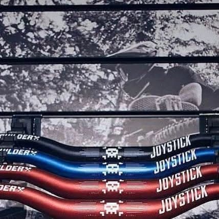 Joystick handlebars in black, blue and red on the parts wall