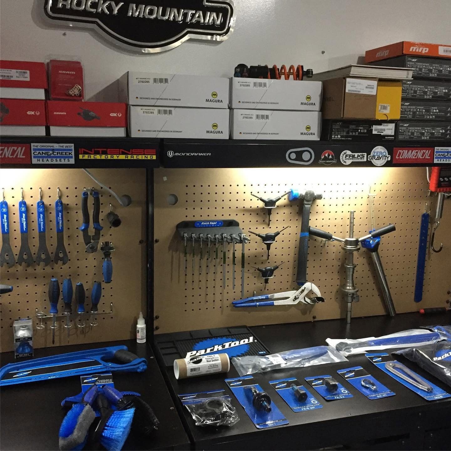 Pegboard tool wall stocked with Park Tool wrenches above the workbench