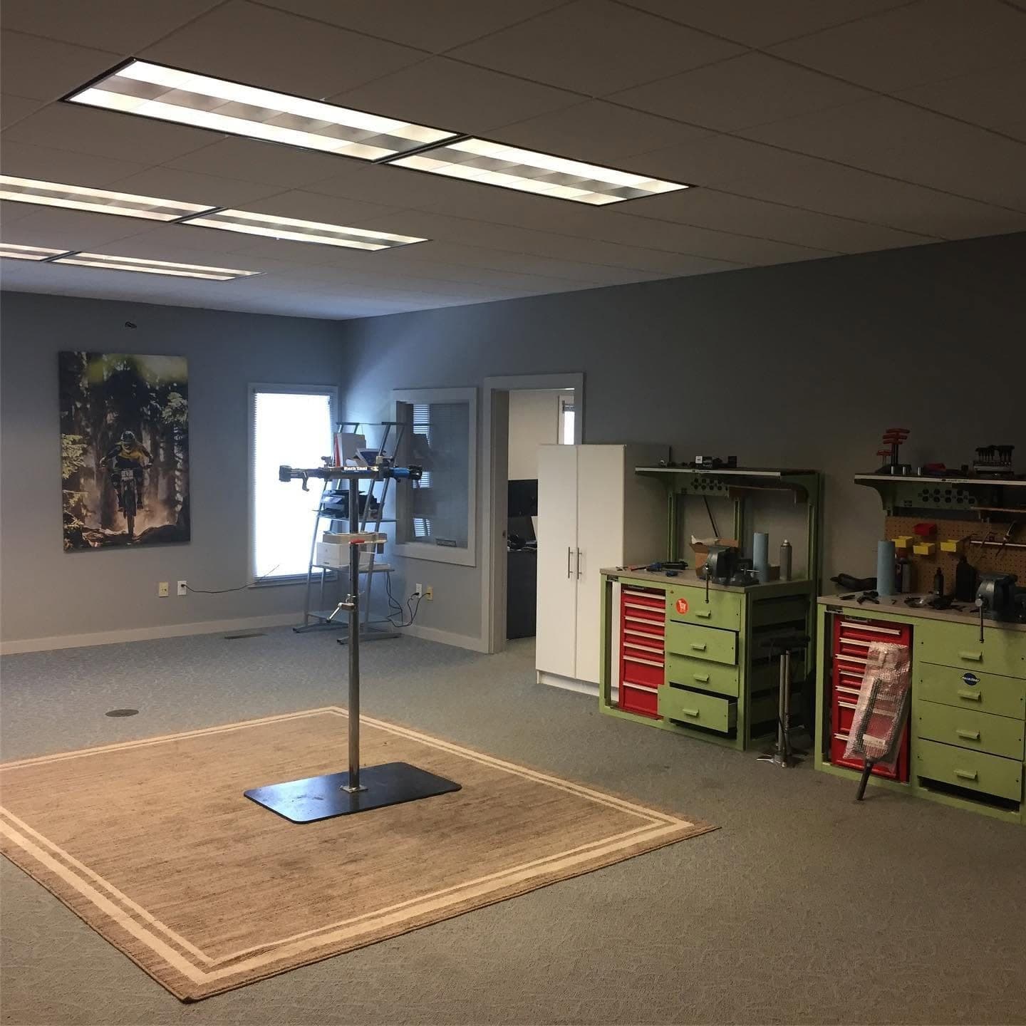 Workshop floor with a repair stand, tool chests and a bike mural